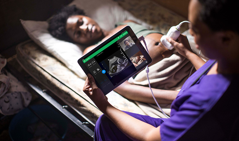 A midwife performing an ultrasound scan on a pregnant woman